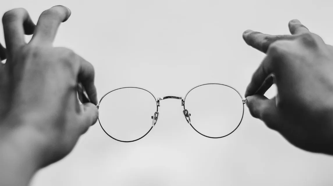 Manos sosteniendo unas gafas con lentes progresivas