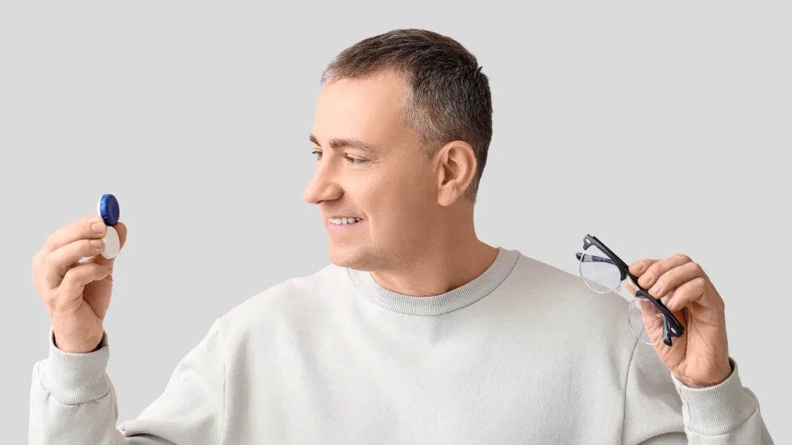 Hombre eligiendo entre lentillas de contacto y gafas